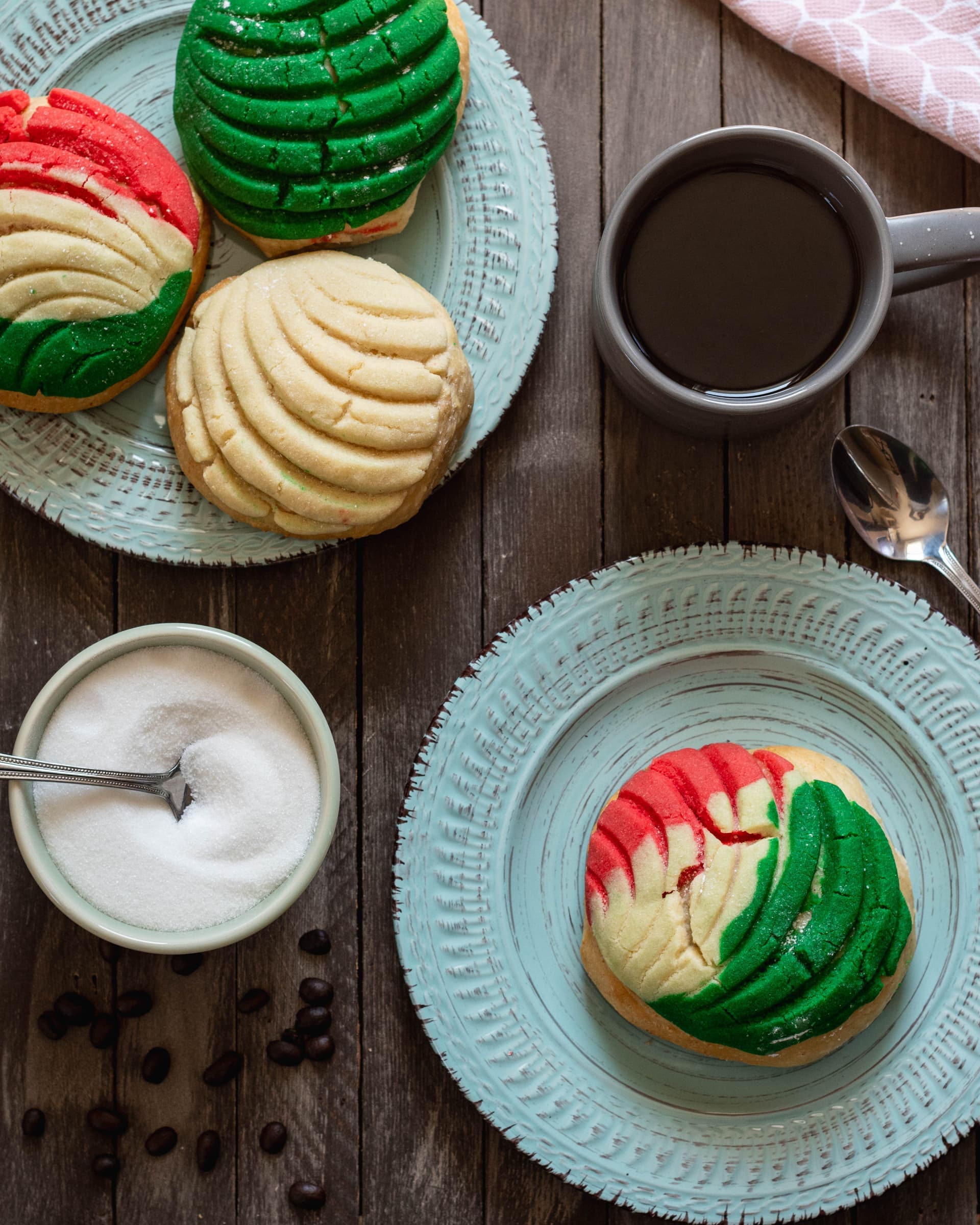 Colorful Mexican conchas (sweet bread) with coffee on turquoise plates