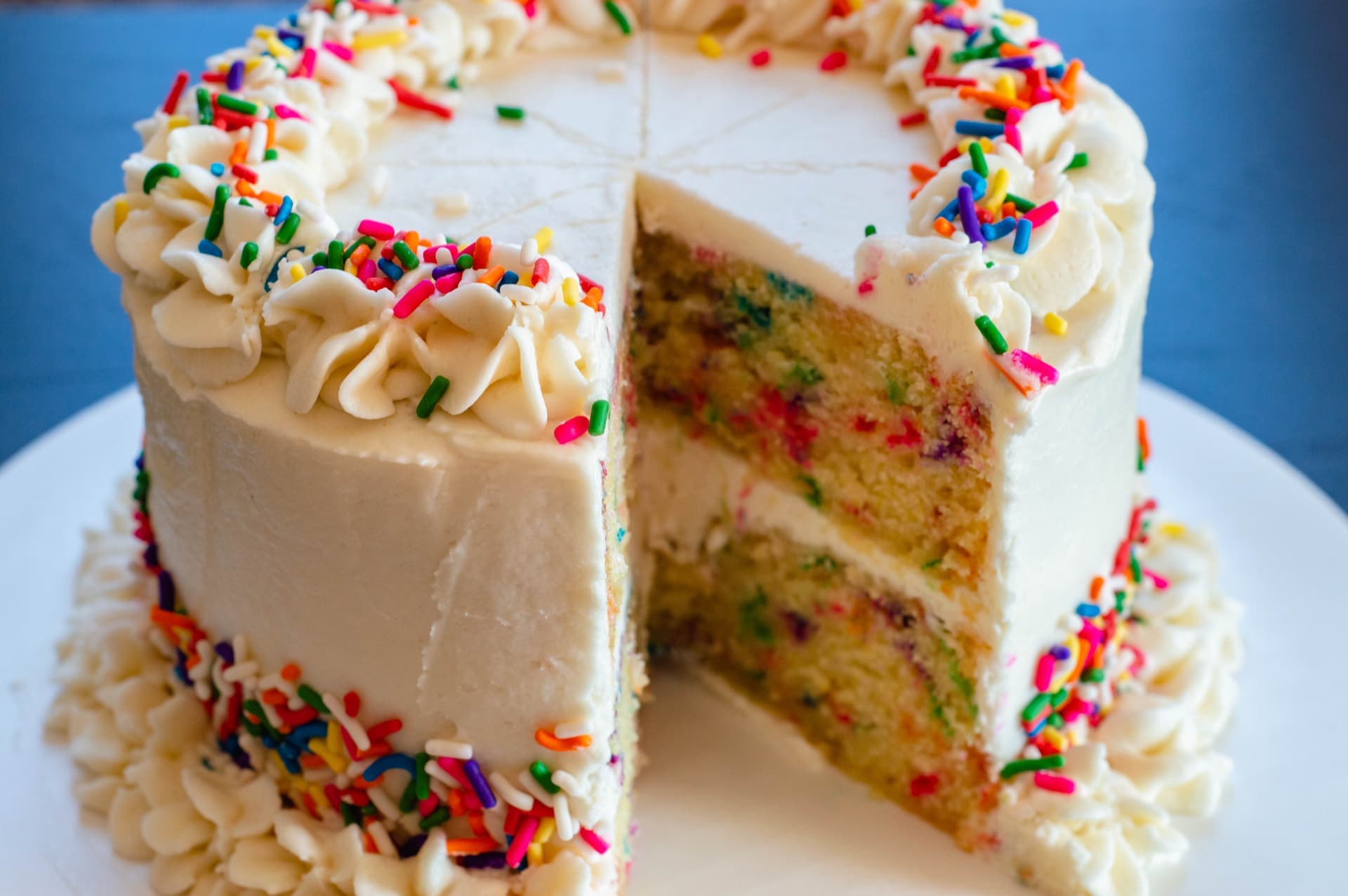 Funfetti birthday cake with colorful sprinkles, slice cut out