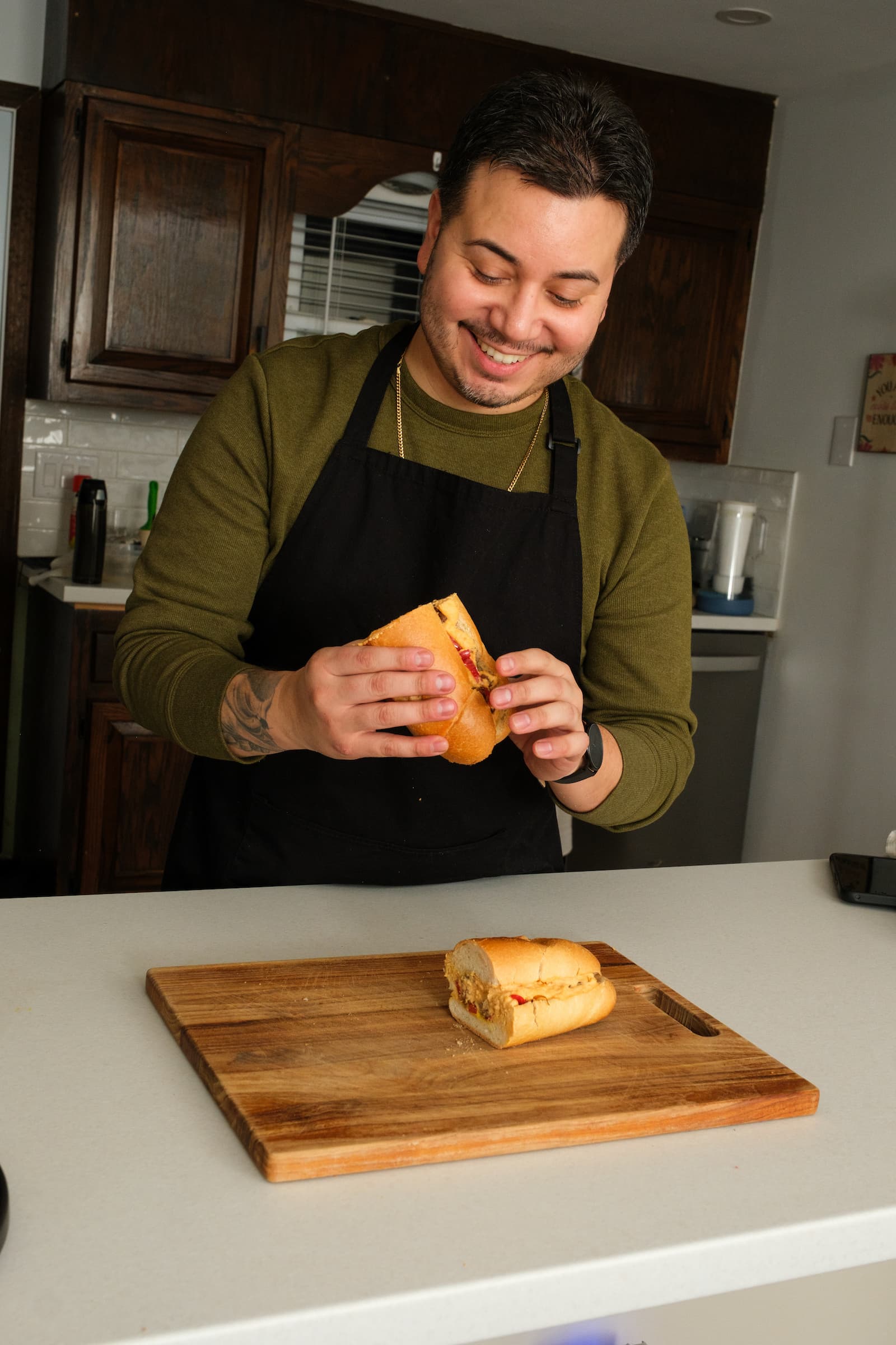 Cutting the vegan Philly cheesesteak on a wooden board